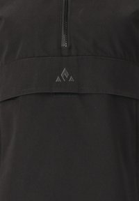 Svart pullover-jacka med en kvartdragkedja, slät textur och en matt logotyp med triangulära detaljer på bröstet.
