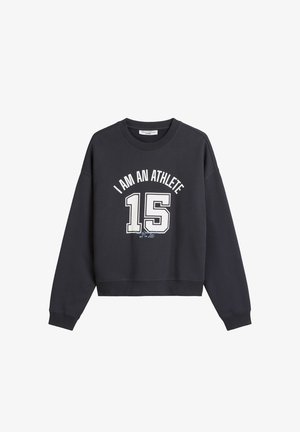Zwarte crewneck sweatshirt met witte tekst "IK BEN EEN ATLEET" en groot nummer "15" gedrukt op de voorkant.