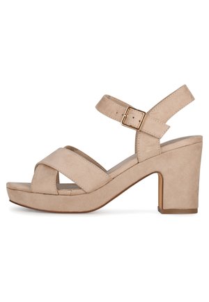 Beige Wildleder-Sandaletten mit Blockabsatz, Kreuzriemen und Knöchelverschluss. Verfügt über eine Plateau-Sohle für zusätzliche Höhe und Stabilität.