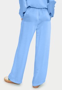 Light blue wide-leg pants made of a smooth fabric; features an elastic waistband and side pockets. Hem is slightly flared.