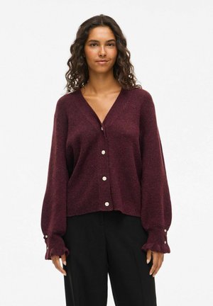 Burgundy cardigan with a V-neck, button closure, and ribbed texture. Features puffy sleeves, ruffled cuffs, and subtle sheen.