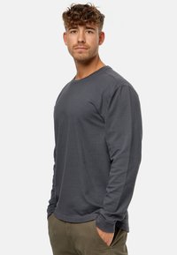 Langärmliges graues Shirt mit Struktur, Rundhalsausschnitt, dezentem Muster, taillierter Schnitt und gerippten Bündchen.