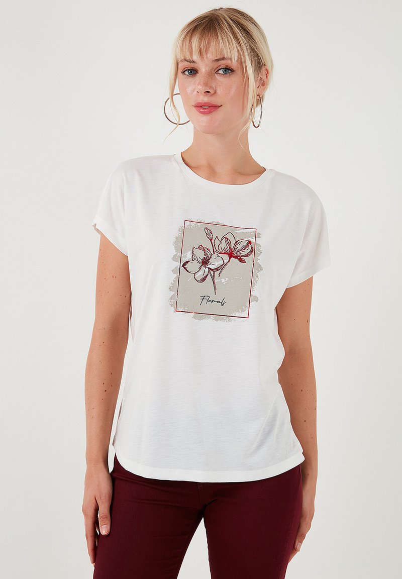 Witte t-shirt met korte mouwen, voorzien van een bloemenprint in rood en grijs, met een ronde halslijn en een ontspannen pasvorm, gecombineerd met donkerrode broek.