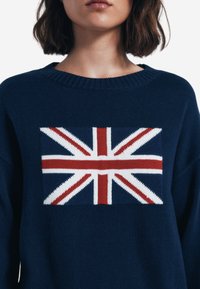 Maglione blu navy con design a maglia della bandiera Union Jack in rosso, bianco e blu, con collo a coste e vestibilità comoda.