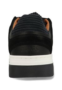 Zwarte sneaker met gestructureerde marineblauwe stof aan de achterkant, slank ontwerp, witte tussenzool en rubberen buitenzool met een subtiel patroon.