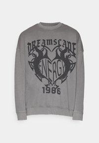 Sudadera gris con cuello redondo, hombros caídos y un diseño impreso que presenta texto y gráficos estilizados en negro. Acentuada con puños de canalé.