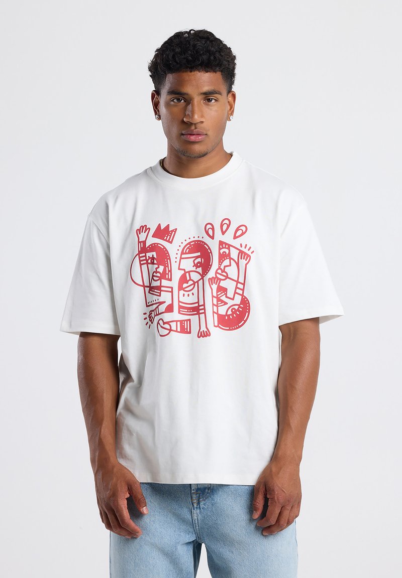 White cotton t-shirt featuring red abstract graphic design. Short sleeves, round neckline, relaxed fit, and soft texture.