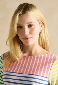 Ribakujundus, millel on roosa, roheline, sinine ja kollane triip. Pehme tekstuur, ümar kaelus ja veidi vabam lõige.