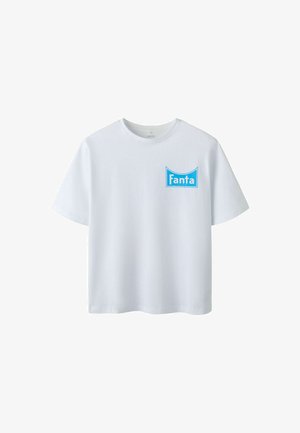 T-shirt blanc à manches courtes avec un logo rectangulaire bleu Fanta sur le côté gauche de la poitrine.