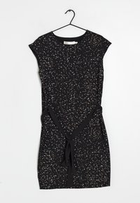 Vestido negro con un patrón floral en blanco y melocotón. Mangas cortas, cinturilla con lazo y tela suave. Está colgado en una percha negra.