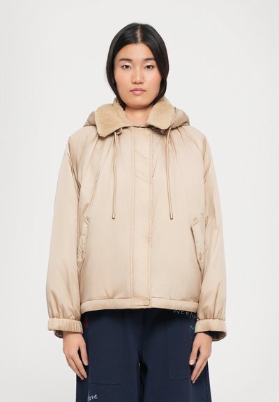 Doudoune de couleur beige clair, avec col en fausse fourrure, capuche à cordon de serrage et poches latérales ; texture lisse et coupe décontractée.