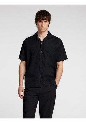Camicia nera a maniche corte realizzata in tessuto leggero, con colletto, chiusura con bottoni e sottili dettagli tessuti sul petto.