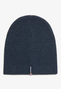 Gorro de punto azul marino hecho de una tela suave; presenta un diseño sin costuras y una pequeña etiqueta de marca con acentos en rojo y blanco.