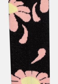 Sorte sokker med et blomstermønster i pink og gul, med struktureret rib og en glat finish mod en lys baggrund.