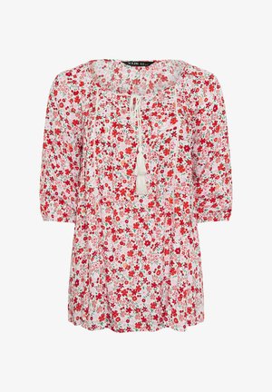 Witte blouse met rood en roze bloemenprint, driekwart mouwen, ronde halslijn en voorstrik met kwastjes.