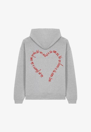 Šedá mikina s kapucňou, na ktorej chrbte sa nachádza červený text v tvare srdca s odkazom "Sme vlny v tom istom mori."