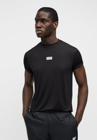 Μαύρο αθλητικό κοντομάνικο μπλουζάκι με στρογγυλή λαιμόκοψη, με μικρό λευκό λογότυπο EA7 στο στήθος. Λείο, ελαφρύ ύφασμα.