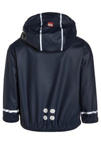 Giacca impermeabile blu navy con cappuccio, strisce riflettenti argentate e quattro cerchi grigi sul retro inferiore. Texture liscia e lucida.