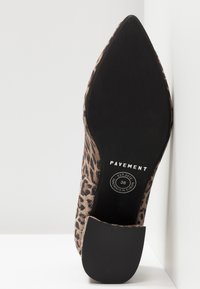 Chaussure à bout pointu imprimé léopard reposant sur le côté, montrant une semelle noire avec le logo Pavement et une étiquette de taille 38.