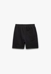Shorts en coton noirs avec une taille élastique et une poche arrière unique. Le tissu a une texture douce et un design simple.