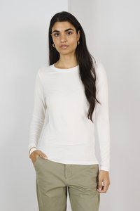 Weißes Langarmhemd aus einem weichen, glatten Stoff mit Rundhalsausschnitt, kombiniert mit olivgrünen Hosen. Minimalistisches Design, keine Muster oder Akzente.