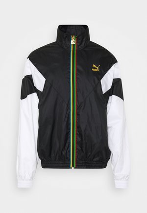 Black and white zip-up jacket with a high collar, featuring a multicolor stripe down the center and a Puma logo in gold.