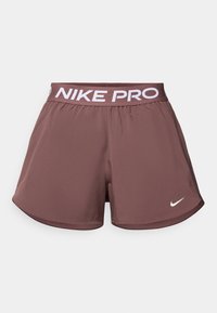 Γυναικεία σορτς Nike Pro σε σκούρο καφέ χρώμα, με λευκό λογότυπο στο αριστερό τελείωμα και λευκή ελαστική μέση με το σήμα της μάρκας. Λείο, ελαφρύ ύφασμα.