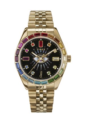 Kultainen metallikello, jossa on musta kellotaulu, värikkäät kristallikoristeet ja teksturoitu ranneke. Kellon kasvoissa on ainutlaatuinen silmäkuvio.