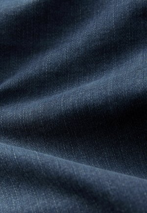 Tessuto di denim blu scuro con una trama liscia, caratterizzato da distintivi motivi di tessitura diagonale e sottili variazioni di colore.
