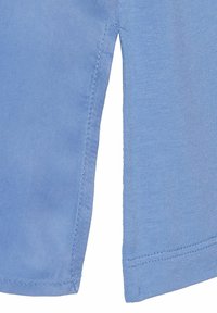 Lichtblauw kortledig shirt met een gladde textuur, met zijsplitten en nette stiksels langs de randen.