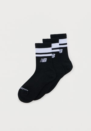 Three black crew socks with white ribbed cuffs, two black stripes, and a white New Balance logo on each sock.