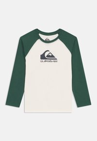 Long-sleeve T-shirt with a cream body and dark green raglan sleeves. Features a black Quiksilver logo on the front. Cotton blend material.