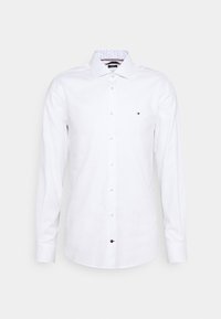 Camicia bianca a maniche lunghe con colletto classico, caratterizzata da un colletto interno a fantasia e un piccolo logo sul lato sinistro del petto.