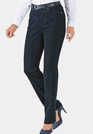 Dunkelblaue Jeans mit geradem Schnitt, ausgestattet mit Fronttaschen und einem Reißverschluss, kombiniert mit einem schwarzen Gürtel und hohen Schuhen.