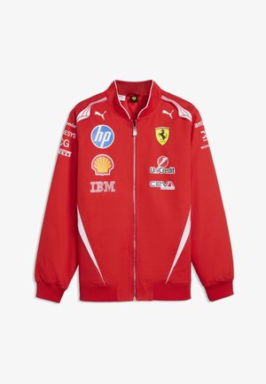 Czerwona sportowa kurtka Ferrari z logo Puma, zamkiem błyskawicznym z przodu oraz logotypami sponsorów, w tym HP, Shell, IBM, UniCredit i Ceva Logistics.