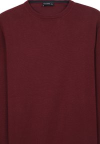 Bordeauxroter Rundhals-Pullover mit langen Ärmeln, gestrickter Textur und einem kleinen schwarzen Etikett im Kragen, das "Calliope Größe L" liest.