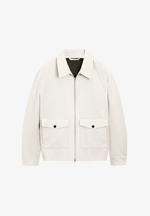 Veste zippée beige clair avec un col, deux poches avant et des accents de boutons noirs. Fabriquée dans un tissu lisse avec une coupe décontractée.