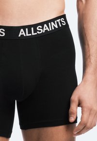 Svarta bomullskalsonger med en figurnära design, som har ett vitlogotypat midjeband och en sömlös textur för komfort.