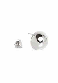 Pendiente de plata con un diseño redondo, liso y cóncavo. Cuenta con un pasador y un respaldo para un uso seguro. Superficie reflectante, estilo minimalista.