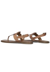 Tan leren sandalen hebben een platte zool, een T-bar ontwerp met verstelbare gespsluitsels en een gestructureerde afwerking langs de voetbed.