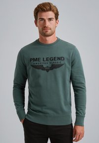 Grøn bomulds sweatshirt med teksten "PME LEGEND AMERICAN CLASSIC" og vinge grafik. Har en rund halsudskæring og ribbede manchetter.