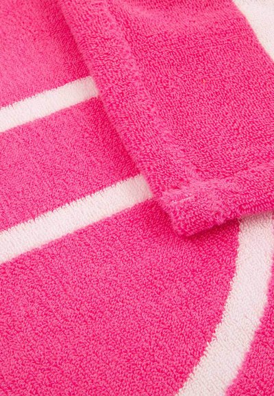 Φωτεινή ροζ πετσέτα με λευκές λωρίδες, απαλό αφράτο ύφασμα πετσέτας, ελαφρώς διπλωμένη γωνία που αποκαλύπτει τη ραφή τελειώματος, λεπτομέρεια με κυκλικό μοτίβο.