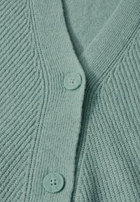 Ljust grön cardigan med en ribbad textur, som har en V-ringning och två runda, texturerade knappar på framsidan.