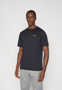 Μαύρο κοντομάνικο μπλουζάκι με στρογγυλή λαιμόκοψη, με λευκό λογότυπο της Nike στο αριστερό στήθος. Απλό, λείο ύφασμα με κλασική εφαρμογή.