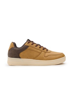 Zapatillas marrones y beige con una parte superior de cuero suave, punta redonda, cordones planos y una suela de goma texturizada con surcos horizontales.