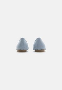 Ballerines en daim bleu clair avec un bout rond, un design minimaliste, un petit talon et un détail de couture discret à l'arrière.