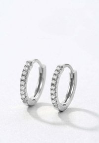 Silberne Creolen mit einer Reihe kleiner klarer Kristalle entlang der Vorderkante, polierte Oberfläche und ein elegantes Design.