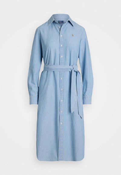 Rochie din denim albastru deschis, cu deschidere frontală cu nasturi, mâneci lungi și o curea asortată la talie. Prezintă un guler ascuțit și un logo mic.