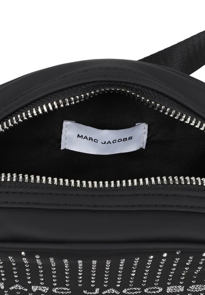 Borsa in pelle nera con accessori in argento, con chiusura a zip e etichetta interna con la scritta "MARC JACOBS." Texture liscia e design minimalista.