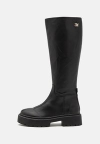 Botine negre, până la genunchi, realizate din piele netedă, cu un toc masiv, margine cusută și un logo argintiu "SM" pe partea superioară.